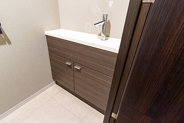 トイレの手洗いカウンター。下の棚にはトイレットペーパーや掃除用具などの収納ができます。