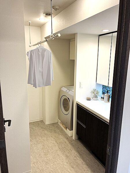洗面所にも室内物干しを設置しています。洗面化粧台の背面側にはリネン庫もあります。（家具・調度品等はイメージです。販売価格には含まれません。）