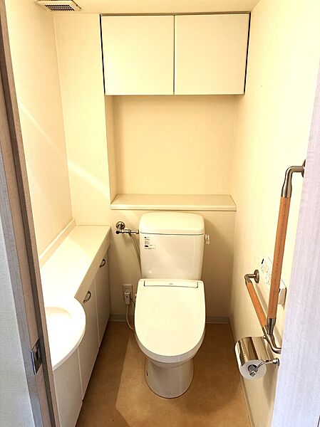 手すり付きトイレ。収納は手洗いカウンター下と吊戸棚の2か所あります