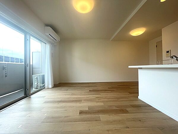 温かみのある木目調フロアが心地よいリビング。広々とした空間で、陽光を感じながらリラックスした時間をお過ごしいただけます。対面キッチンでお料理中も会話が弾みます。