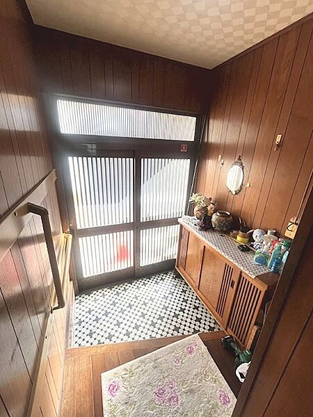 温もりを感じる木目調の壁が広がる玄関。デザインタイルが個性を演出し、来客を迎え入れます。