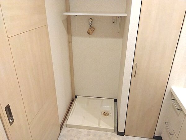 洗濯機パンと上部棚が設置された洗面所です。扉付き収納もあり、洗剤などのストックもすっきり収まります。