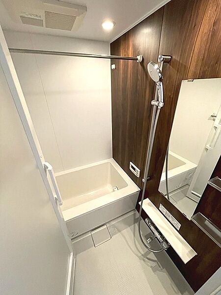 木目調のアクセントパネルが落ち着いた雰囲気を演出する浴室。一日の疲れを癒すバスタイムをお過ごしいただけます。浴室乾燥機も備わり、雨の日の洗濯物も安心です。