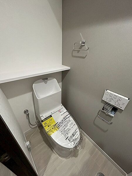 清潔感あふれるトイレ空間は、毎日の生活を快適にサポート。壁の収納棚が、小物や芳香剤の設置に便利です。