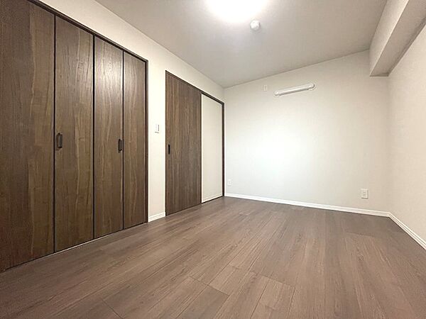 木目調のフローリングと大型収納が魅力の居室。プライベートな時間を豊かに彩る空間です。