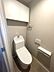 トイレ：清潔感あふれるトイレは、上部収納とトイレットペーパーホルダーを完備。ゆとりの空間で、快適なひとときをお過ごしいただけます。