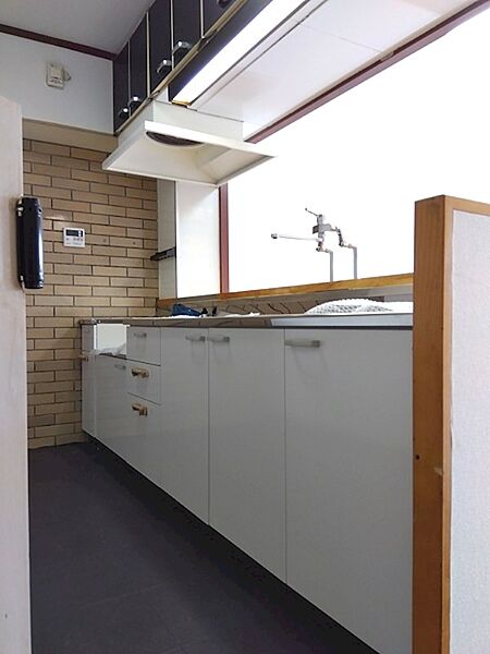明るい光が差し込むキッチンは、レンガ調の壁が特徴的。たっぷりの収納スペースが、すっきりとした空間を保ちます。料理の時間を快適に。