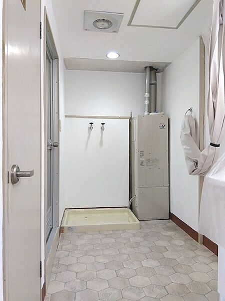 白を基調とした洗面室は清潔感があります。洗濯機置き場も確保されており、機能的な空間です。