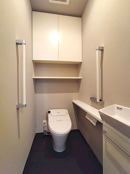 収納棚と飾り棚を設け、使い勝手とデザイン性を両立したトイレです。手洗い器も設置し、清潔感のある空間に。