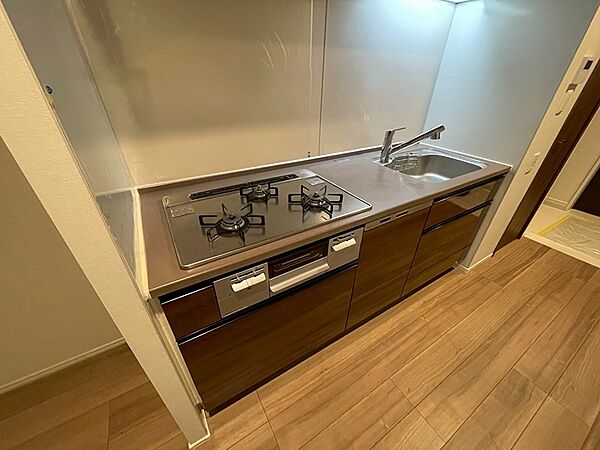 シンクと3口ガスコンロが一体となったシステムキッチン。収納も充実しており、調理器具をすっきりと収納できます。快適な調理空間で、毎日のお料理をお楽しみください。