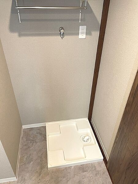 洗濯機置き場は、水栓とコンセントが整っており、機能的な空間です。上部のタオル掛けも便利にお使いいただけます。