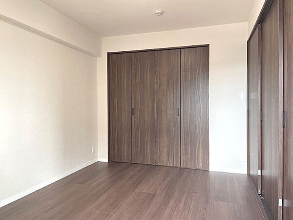 落ち着いた色合いのフローリングと収納が、お部屋に統一感を与えます。明るい壁が開放感を演出。