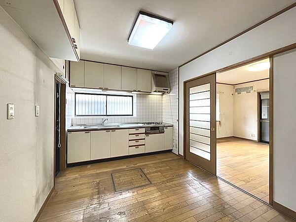 明るい光が差し込むキッチンは、豊富な収納スペースを完備。引き戸を開ければリビングへと繋がり、スムーズな家事動線が期待できます。