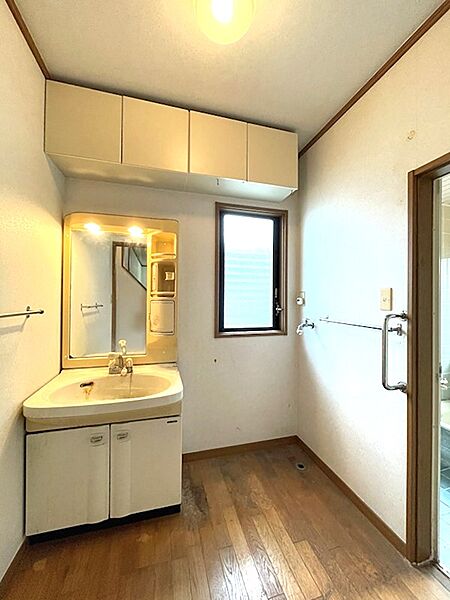 窓があり、明るい光が差し込む洗面所。上部収納で、タオルや洗剤をすっきりと収納できます。毎日の身支度を快適に。