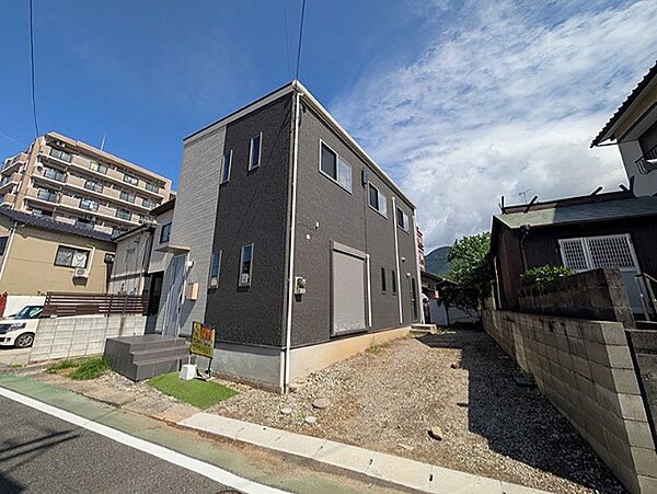 モダンな外観の建物と青空が調和する現地写真です。周辺は閑静な住宅街で、落ち着いた暮らしが期待できます。現地でぜひ雰囲気をご確認ください。