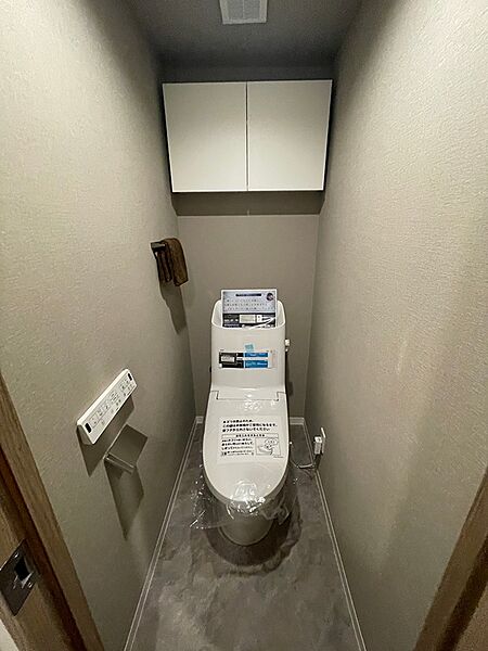 落ち着いた色合いでまとめられた空間は、日々の暮らしに心地よさを提供します。上部には収納棚も備え付けられています。