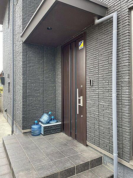 落ち着いたトーンのタイルが印象的な玄関アプローチ。セキュリティにも配慮された安心感のある住まいです。