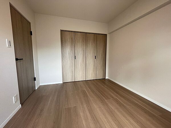温かみのある木目調の床とドアが心地よい居室。大きな収納で空間をすっきり保てます。