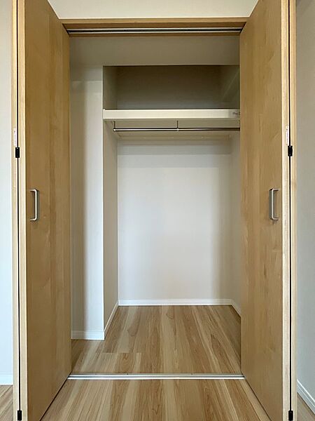 広々としたクローゼットで、衣類や小物もすっきり収納できます。ハンガーパイプと枕棚で使い勝手の良い空間です。