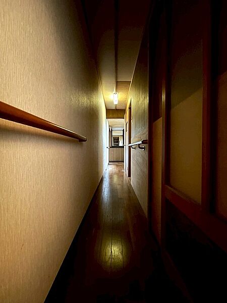 温もりを感じる木の質感と、奥へと続く廊下が広がりを感じさせる空間。手すり付きで、安心感のある設計です。