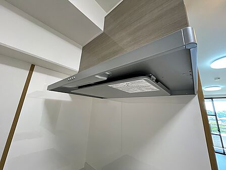 明るいホワイトの壁に、ウッド調のレンジフードが落ち着いた印象を与えます。お料理の時間を快適にサポートします。