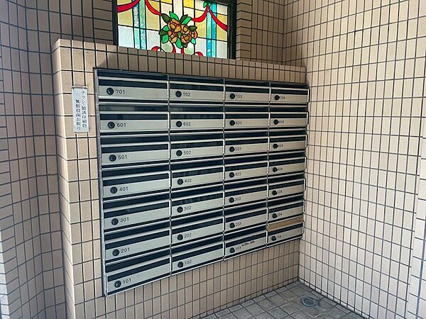 メールボックスは整然と並び、各住戸へ郵便物を安全にお届けします。ステンドグラスが彩るエントランスで、日々の暮らしを美しく演出。