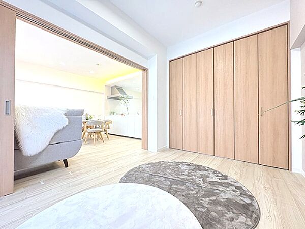 リビングと隣接する居室は、引き戸を開放すれば一体空間としても利用可能。大容量の収納も備え、すっきりとした暮らしを叶えます。