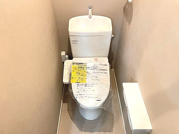 温水洗浄便座付きのトイレです。壁面は落ち着いた色合いで、清潔感のある空間に。快適な毎日をサポートします。