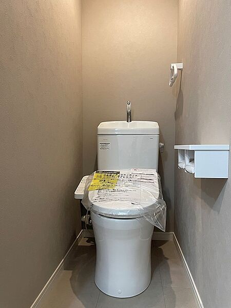 清潔感のあるトイレは、温水洗浄便座と手洗いカウンターを備え、毎日を快適にサポートします。トイレットペーパーホルダーも設置済みです。