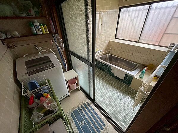窓から光が差し込む明るい浴室。洗濯機置場も備わり、家事動線にも配慮されています。日々の疲れを癒すバスタイムをお過ごしください。