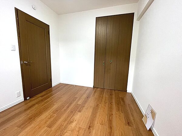 クローゼットを備えた洋室は、ブラウンのフローリングが落ち着いた空間を演出します。収納力もあり、すっきりと暮らしたい方におすすめです。