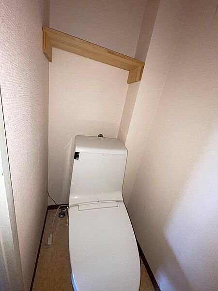 清潔感のあるトイレ空間。上部の棚は、収納や小物のディスプレイにも活用できます。日々の快適さを支える空間です。
