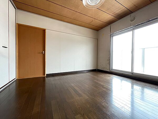 木の温もりを感じる天井とダークブラウンのフローリングが落ち着いた雰囲気を醸し出す居室。大きな窓が開放感をもたらします。