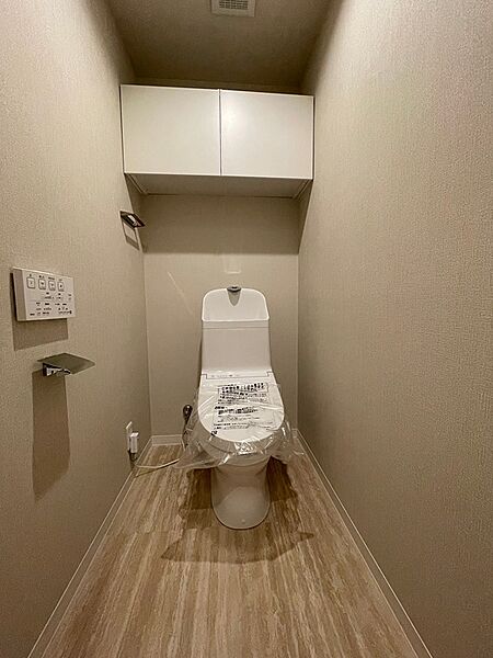 機能的な収納が設けられたトイレ空間。温水洗浄便座で快適にご利用いただけます。
