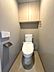 トイレ：収納棚付きで機能的なトイレ空間。落ち着いた色合いの壁紙が心地よい雰囲気を演出します。