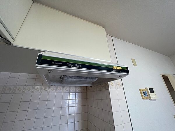 調理中の換気をサポートするレンジフードを備えたキッチンです。上部には収納もございます。