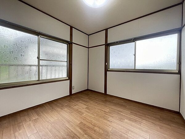 木目調のフロアとシンプルな壁面が調和した室内。窓から明るい光が差し込み、お部屋全体を明るく演出します。