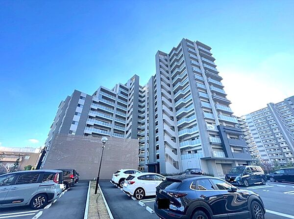 青空に映えるスタイリッシュな外観のマンション。敷地内駐車場を完備し、快適なカーライフをサポートします。