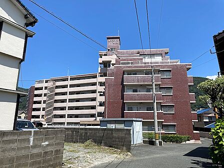 街並みに溶け込むマンション。周辺には山並みが広がり、自然を感じられる立地です。穏やかな暮らしをお求めの方におすすめです。
