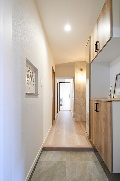 明るい光が差し込む玄関ホール。空間に合わせた造作収納が、洗練された印象を与えます。日々の暮らしを彩る、上質なエントランスです。