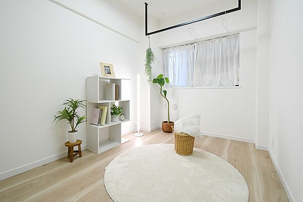 白を基調とした室内は、光を多く取り込み明るい空間を演出します。観葉植物やデザイン性のある棚がお部屋を彩り、日々の暮らしに心地よさをもたらします。