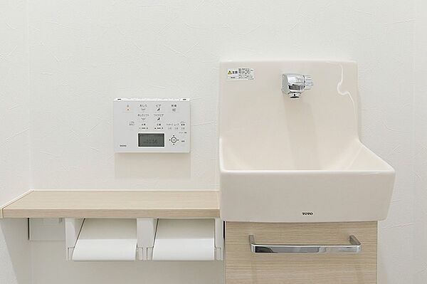清潔感あふれるトイレ空間。手洗いカウンターとリモコン、ペーパーホルダーも完備し、快適な毎日をサポートします。