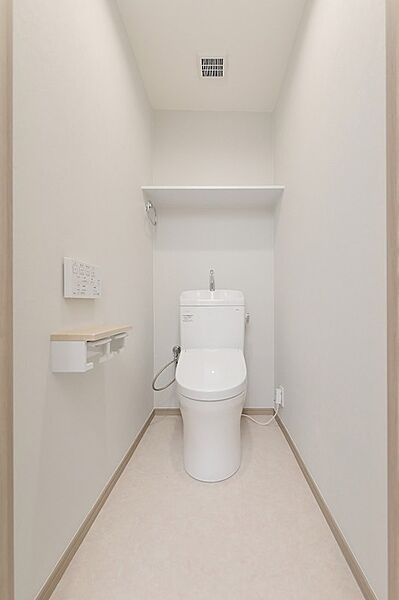 清潔感あふれるシンプルなトイレ空間。上部の棚は、収納や飾り付けにも活用できます。日々を快適に過ごせる工夫が詰まっています。