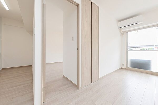 明るい木目のフローリングが印象的な居室。隣接する部屋との間にドアがあり、生活スタイルに合わせて柔軟な使い方が可能です。