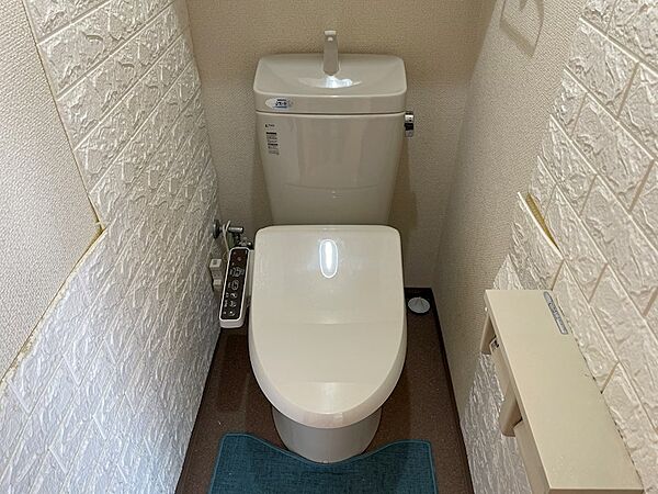 ホワイトの壁紙と清潔感のあるトイレが調和し、心地よい空間を演出。快適な機能も備え、日常をサポートします。