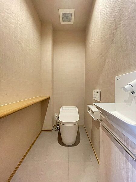 落ち着いたトーンで統一されたトイレ空間。手洗いカウンターと収納棚で、機能性と心地よさを両立しました。日々の暮らしに配慮した設計です。