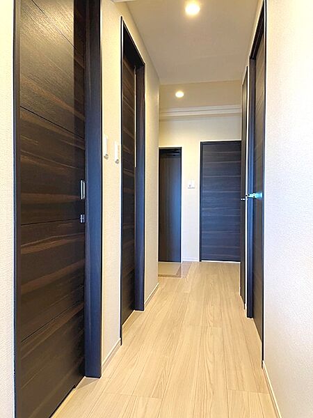 温かみのある木目調フローリングと落ち着いた色のドアが調和し、居住空間を美しく彩ります。洗練された内装で日々の暮らしを快適に。
