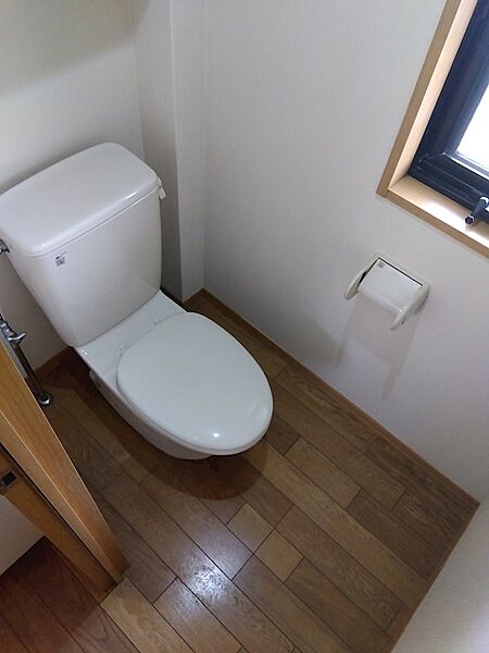 換気窓付きで明るく快適なトイレです。木目調の床材が空間に温かみを添えます。