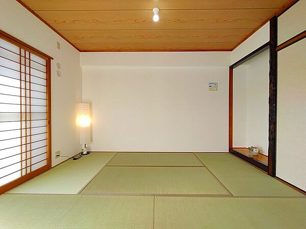 和の趣が心地よい、広々とした和室。障子から差し込む柔らかな光が、畳の香りと共に落ち着いた空間を演出します。客間や寝室としても活用でき、様々なシーンに対応可能です。