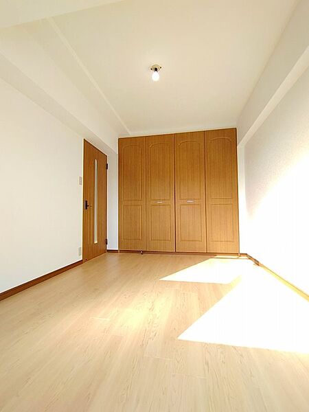 たっぷり収納できるクローゼット付きの居室。大きな窓から光が差し込み、明るく開放的な空間です。シンプルながらも機能的なお部屋は、居心地の良いプライベート空間を演出します。